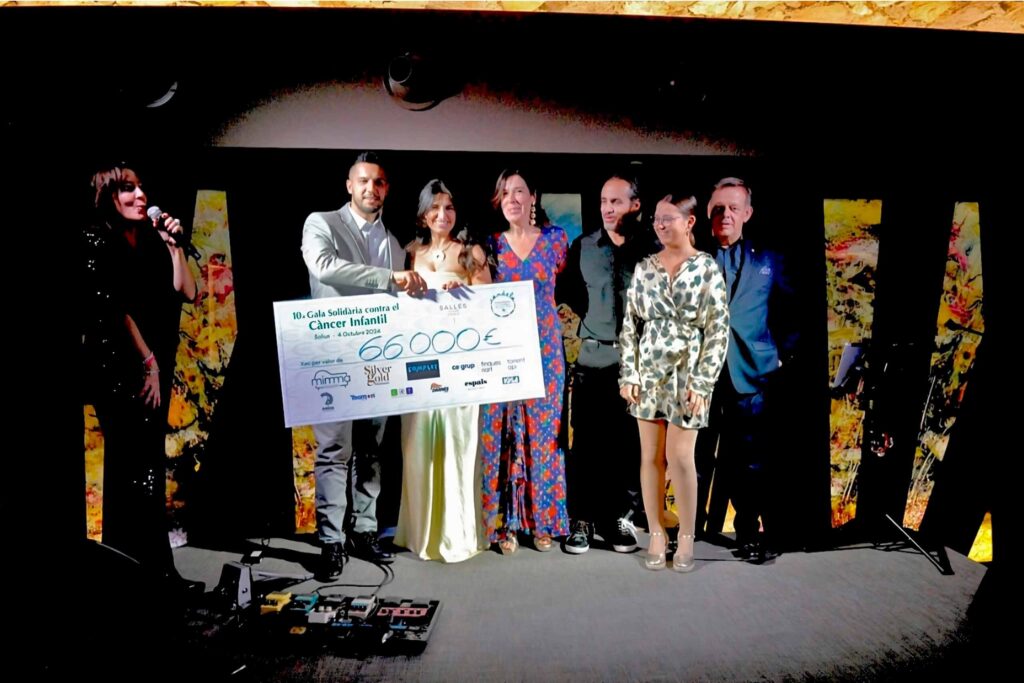 Varias personas sostienen el cheque con 66.000€ reunidos en la Gala Solidaria contra el Cáncel Infantil, en el que aparece el logo de SilverGold Patrimonio